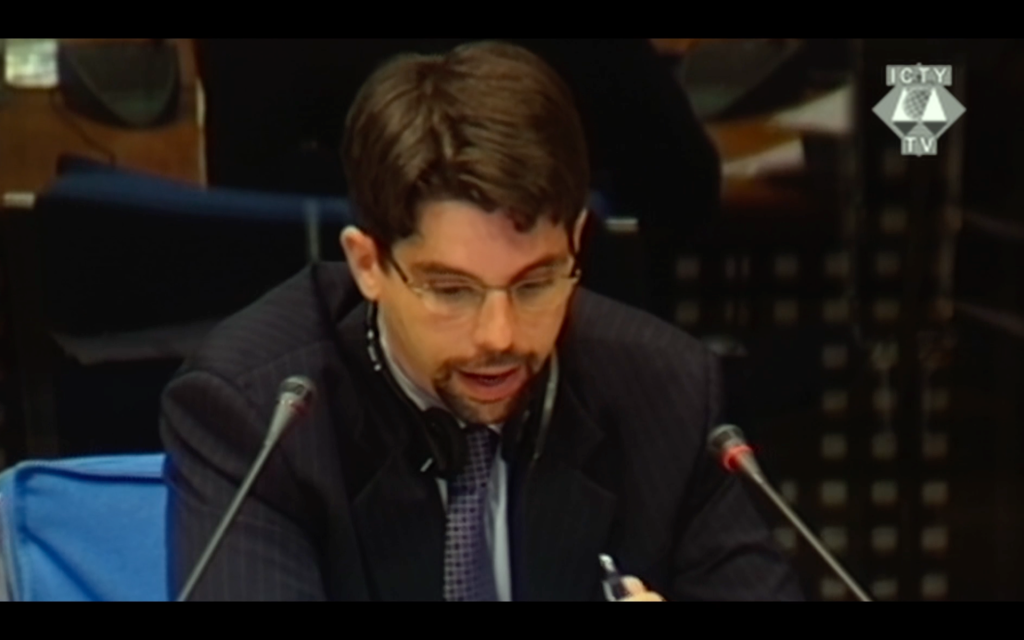 Screen-grab from E-TEAM: Fred Abrahams testifying at the trial of Slobodan Milošević in The Hague. 